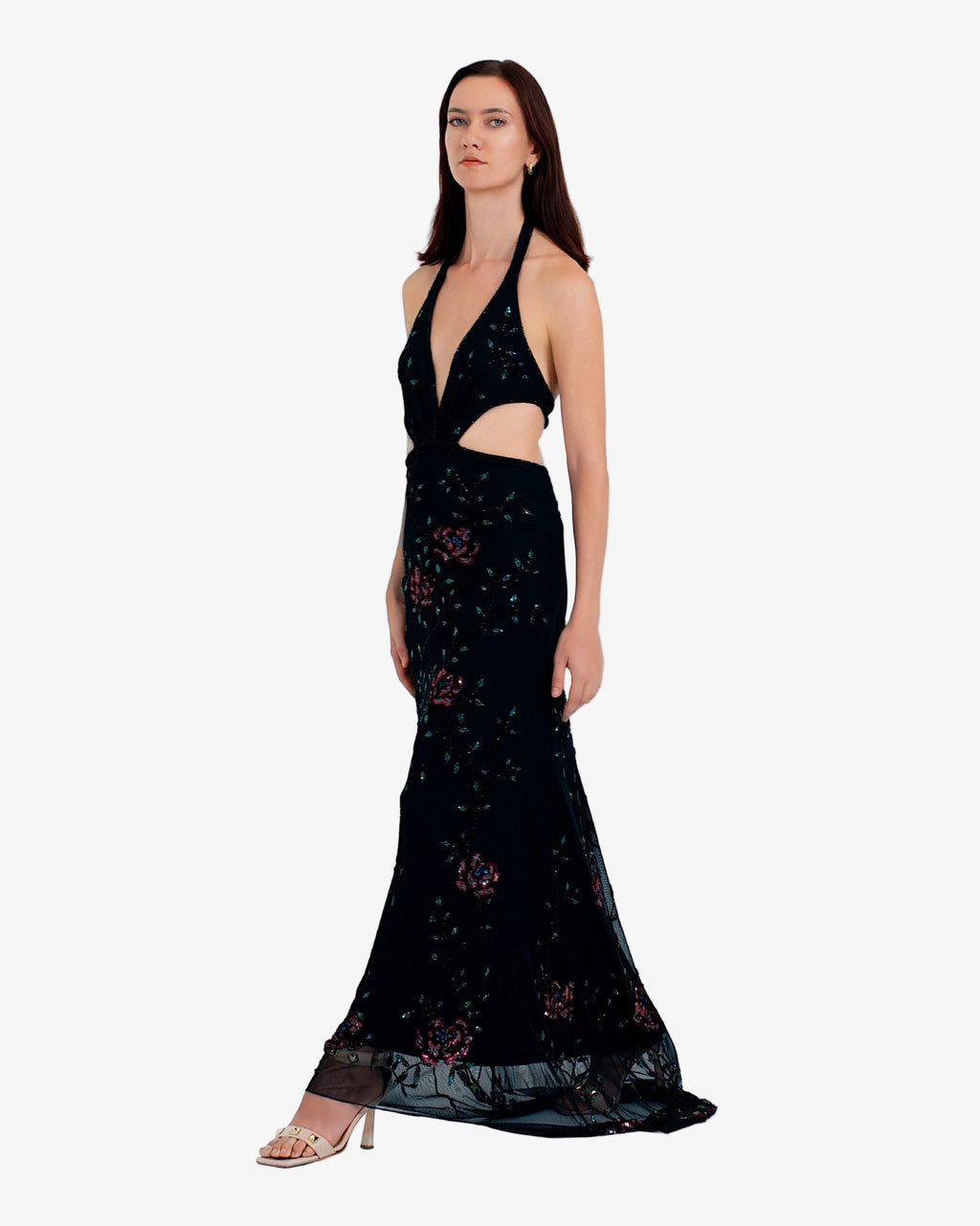 Woman wearing a black evening gown with floral patterns on a white background