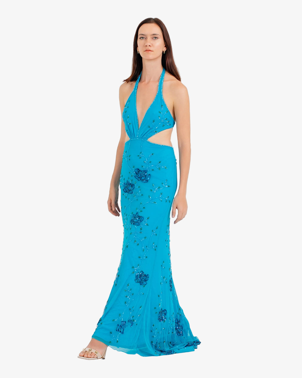 Woman wearing a blue evening gown with floral embellishments on a white background