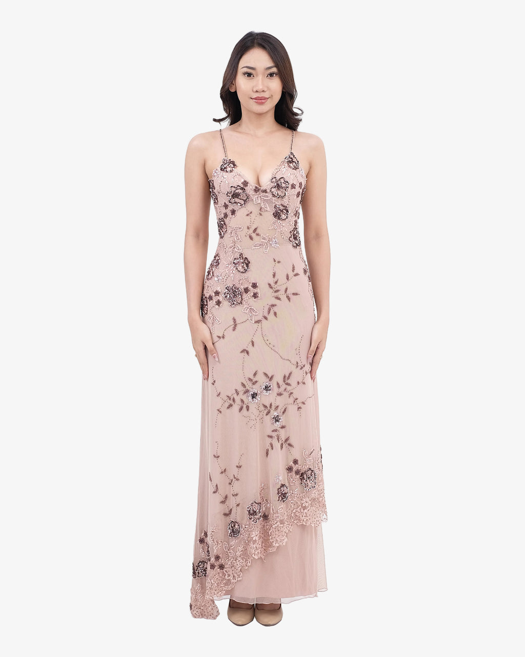 Woman wearing a nude floral evening gown on a white background