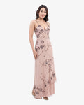 Woman wearing a nude floral dress on a white background