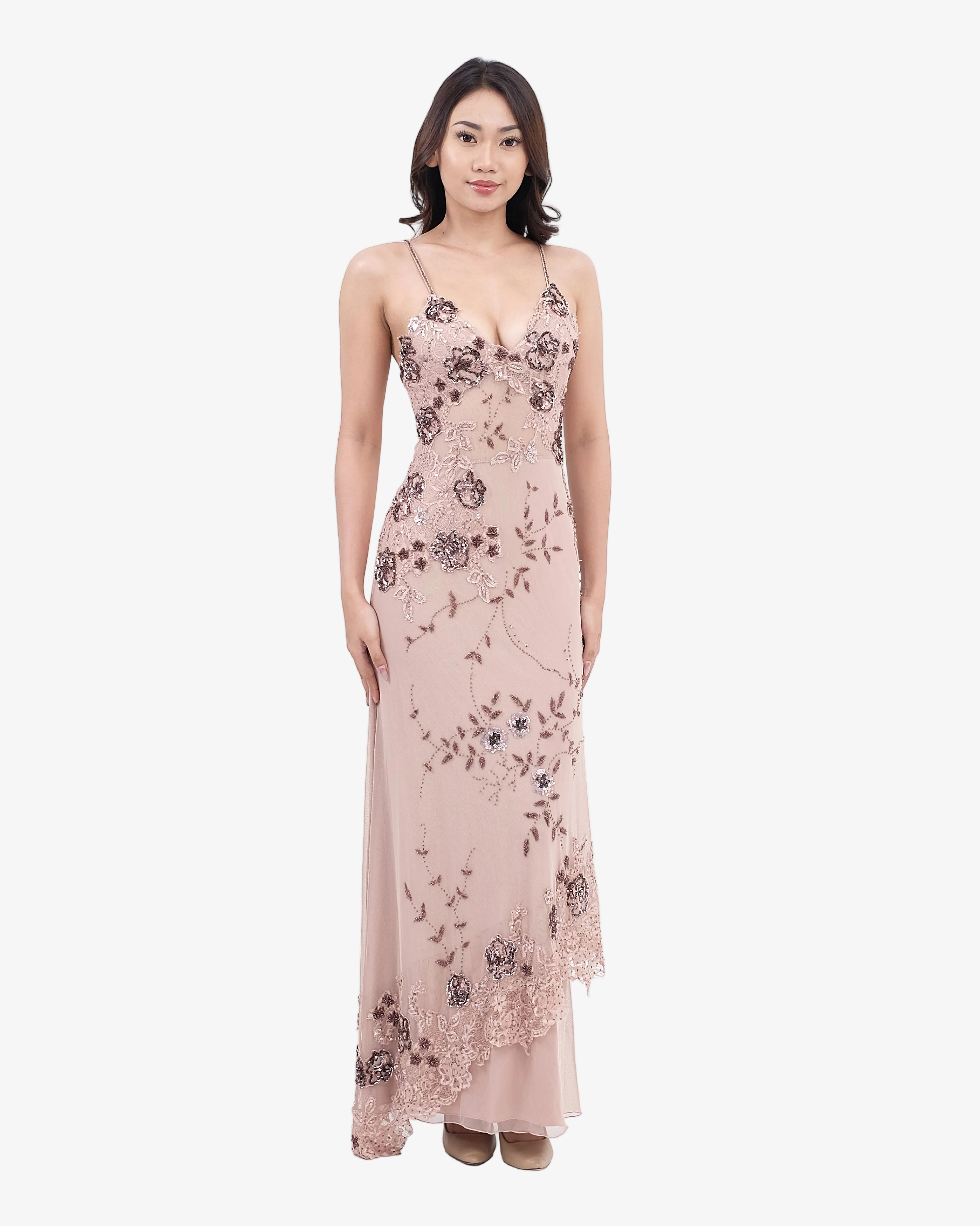 Woman wearing a nude floral dress on a white background