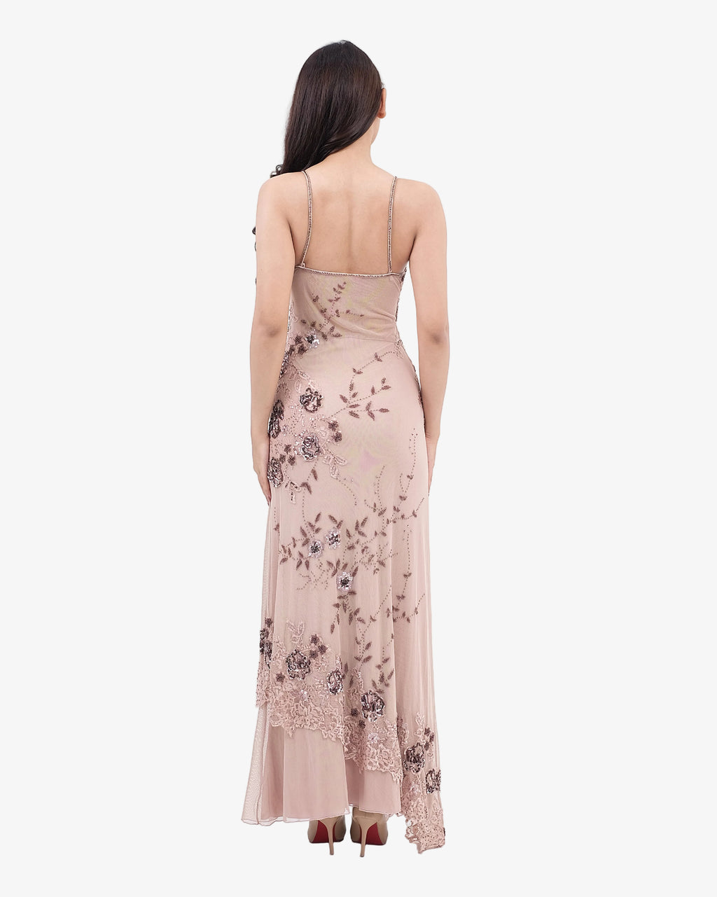 Woman wearing a nude floral evening gown on a white background