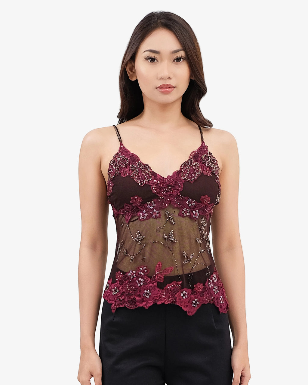 Woman wearing a floral lace top on a white background